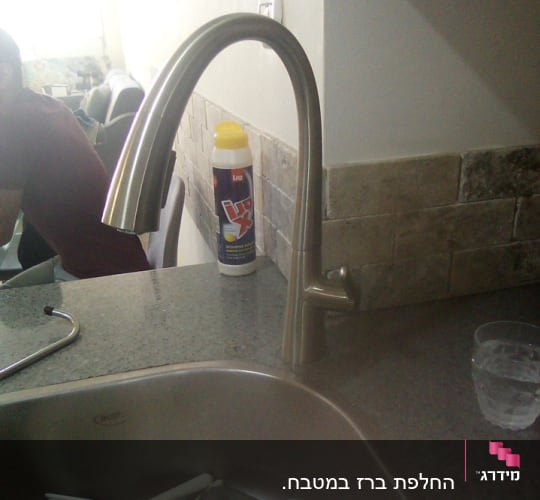 ברז נירוסטה במטבח עם כלים בכיור